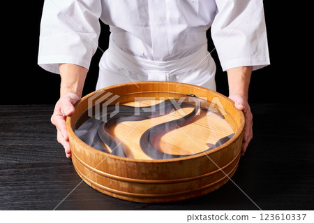 Chef holding a bucket of eels 123610337