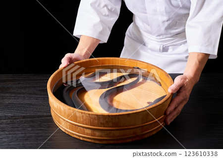 Chef holding a bucket of eels 123610338
