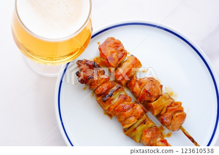 用炭烤烤雞肉串(negima)喝啤酒 用炭烤烤雞肉串(negima)喝啤酒 123610538