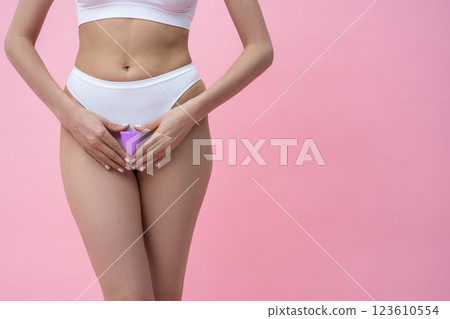 Woman holding hygienic menstrual cup promoting natural feminine care for protection during periods 123610554