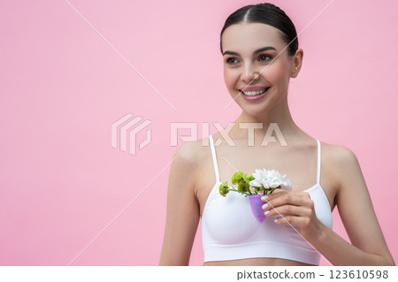 Female holding reusable silicone cup with flowers intimate care and monthly cycle 123610598