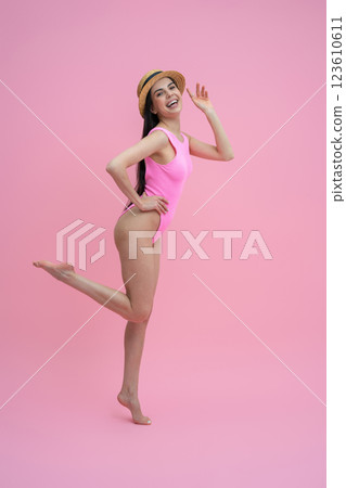 Enjoyed pretty young woman in pink bodysuit and straw hat Enjoyed pretty young woman in pink bodysuit and straw hat 123610611