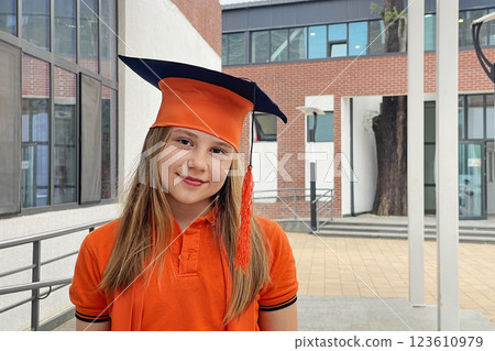 Portrait of happy little girl student in school uniform during graduation ceremony Portrait of happy little girl student in school uniform during graduation ceremony 123610979