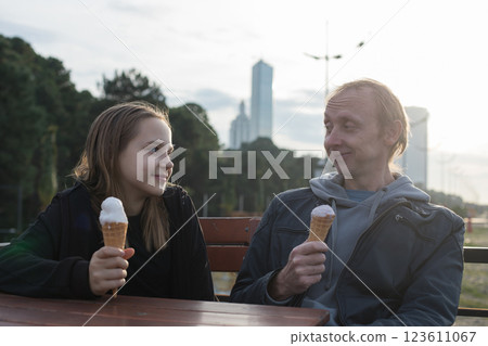 Happy father and daughter sitting in street caffee and eating ice cream 123611067