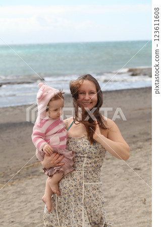Joyful young mother and daughter baby girl. Young woman and child one year old 123611608