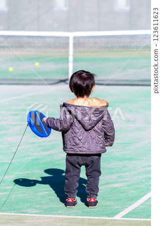 Boy playing on tennis court 123611623
