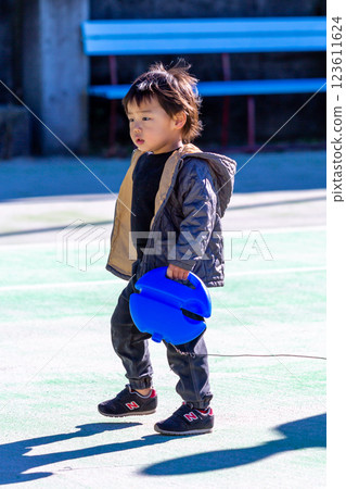 Boy playing on tennis court 123611624