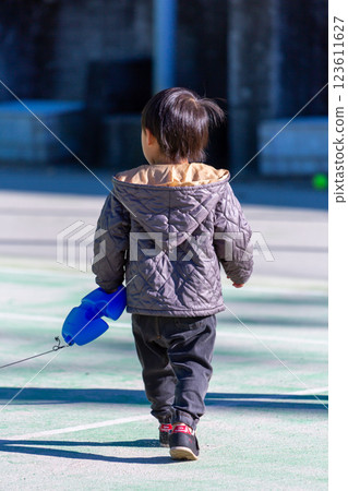 Boy playing on tennis court 123611627