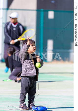 Boy playing on tennis court 123611629
