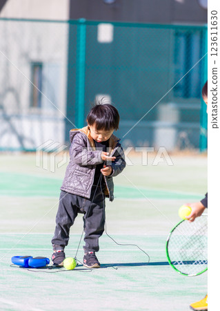 Boy playing on tennis court 123611630