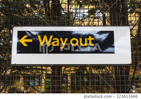 Way Out Sign with Arrow Captured in an Outdoor Setting with Fenced Background Way Out Sign with Arrow Captured in an Outdoor Setting with Fenced Background 123611666
