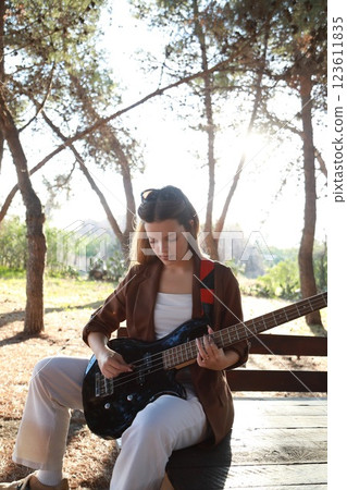 Girl Plays The Bass Among The Trees In The Countryside Girl Plays The Bass Among The Trees In The Countryside 123611835