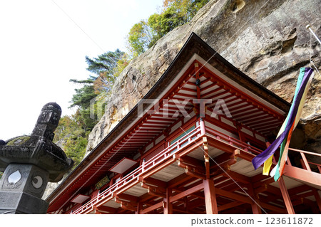 位於懸崖底部洞穴內的達谷岩屋毗沙門堂和懸崖上的秋葉 位於懸崖底部洞穴內的達谷岩屋毗沙門堂和懸崖上的秋葉 123611872