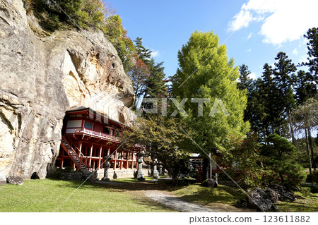 Takkoku-no-Iwaya Bishamon-do Temple, built in a cave at the bottom of a cliff, and autumn leaves on the cliff Takkoku-no-Iwaya Bishamon-do Temple, built in a cave at the bottom of a cliff, and autumn leaves on the cliff 123611882