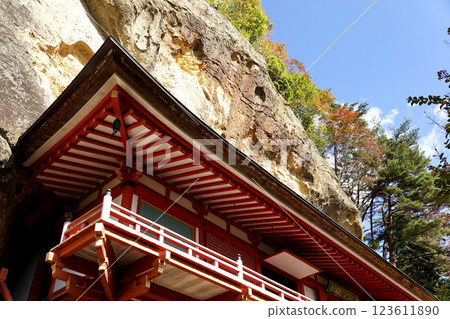Takkoku-no-Iwaya Bishamon-do Temple, built in a cave at the bottom of a cliff, and autumn leaves on the cliff 123611890