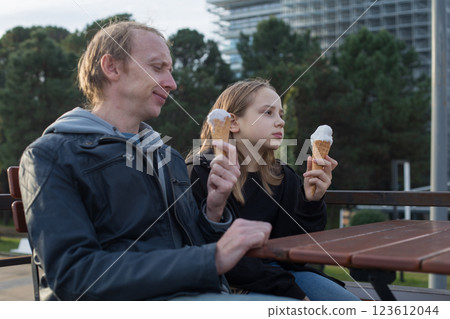 Happy Father and Daughter Enjoying Ice Cream Together outdoors in street cafe 123612044