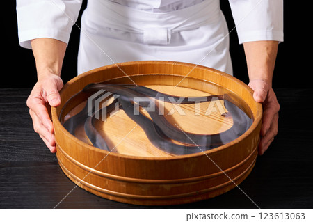 Chef holding a bucket of eels Chef holding a bucket of eels 123613063