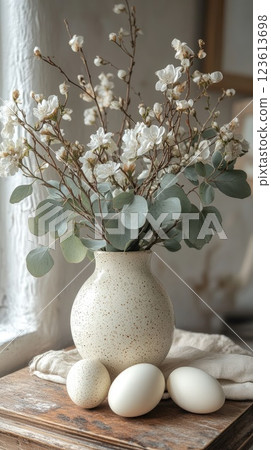 Soft spring decoration with flowers and eggs on a wooden table near a window 123613698
