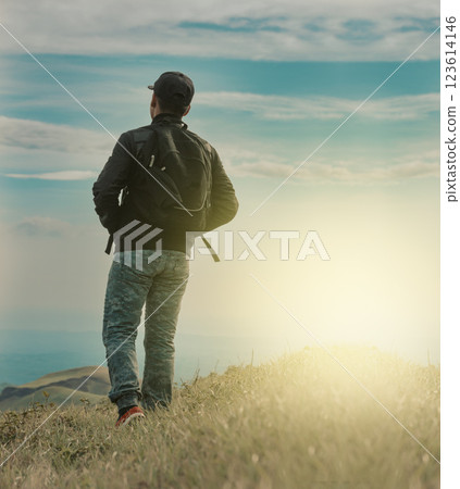Rear view of backpacker man walking in the mountain. Low angle of backpacker man walking in the countryside 123614146
