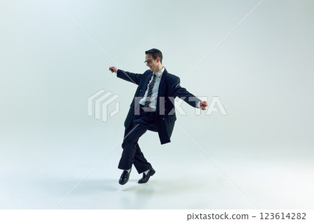 Young businessman moving with open arms and playful energy against white studio background. Young businessman moving with open arms and playful energy against white studio background. 123614282