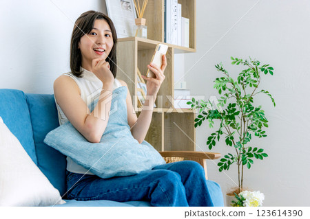 一個微笑的女人看著智能手機 123614390