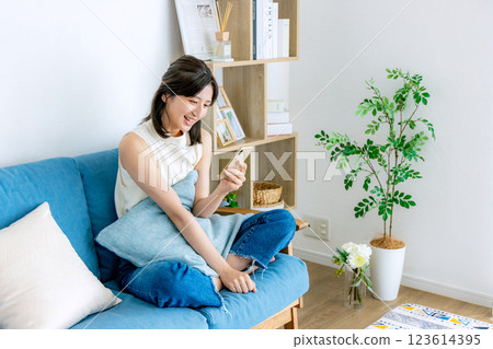 一個微笑的女人看著智能手機 123614395