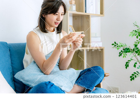 A smiling woman looking at a smartphone A smiling woman looking at a smartphone 123614401