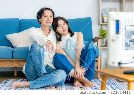 Young couple relaxing in the living room watching TV Young couple relaxing in the living room watching TV 123614411