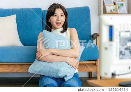 Woman relaxing in her room watching TV Woman relaxing in her room watching TV 123614414