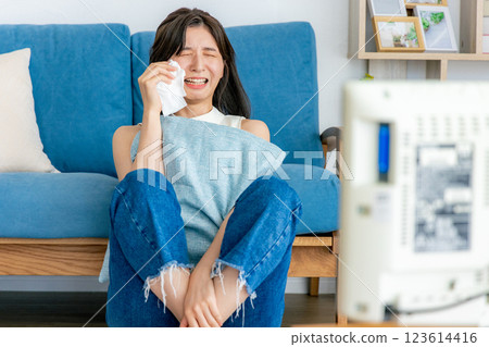 A woman who cries watching TV A woman who cries watching TV 123614416