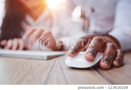 black man holding a computer mouse on the table, close-up black man holding a computer mouse on the table, close-up 123616109