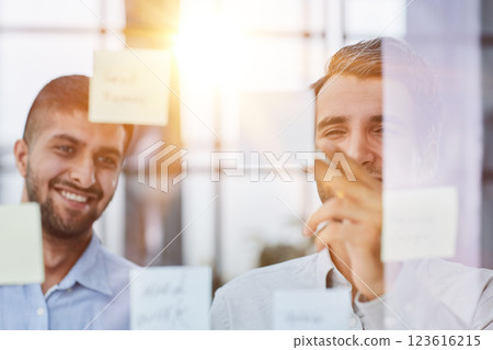 two successful businessmen in the office discuss a plan on stickers 123616215