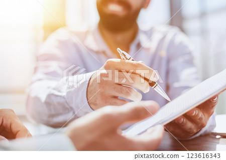 Businessman hand signing contract paper at the desk Businessman hand signing contract paper at the desk 123616343