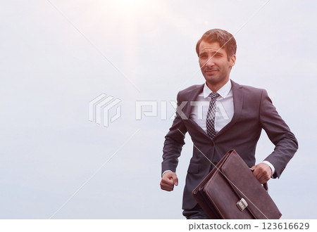 Studio shot of a mature businessman running with a briefcase isolated against the sky. Studio shot of a mature businessman running with a briefcase isolated against the sky. 123616629