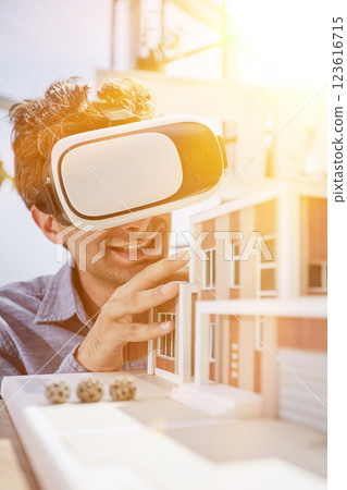 man sits in the office of a realtor and looks at the layout of the apartment in virtual reality glasses. man sits in the office of a realtor and looks at the layout of the apartment in virtual reality glasses. 123616715