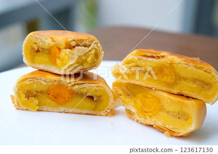 Delicious Cantonese moon cake with lotus seed pastry and salted egg yolk for Mid-Autumn Festival food mooncake on gray table background, holiday celebration serving. Delicious Cantonese moon cake with lotus seed pastry and salted egg yolk for Mid-Autumn Festival food mooncake on gray table background, holiday celebration serving. 123617130