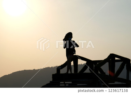 Silhouette of young woman at sunset and big sun. 123617138