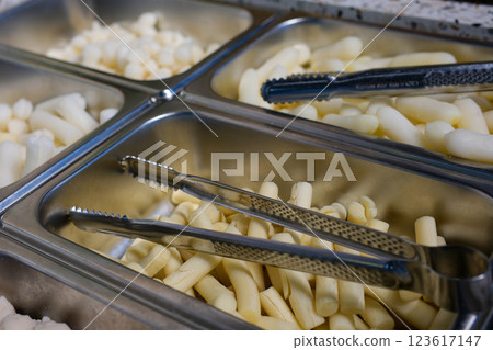 raw pasta lunch service station with different kinds of pasta in trays. raw pasta lunch service station with different kinds of pasta in trays. 123617147