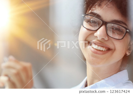 a girl in a modern office behind glass uses sticky notes and makes notes 123617424