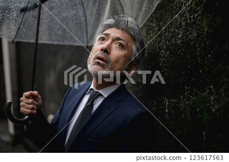 A businessman pointing an umbrella A businessman pointing an umbrella 123617563