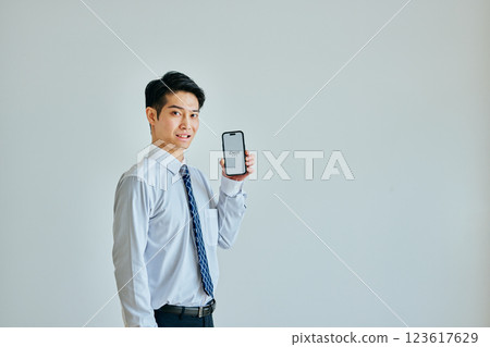 Young man in his 20s with a smartphone iDeCo 123617629