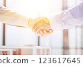 handshake against the background of a model of a house under construction. client and designer 123617645