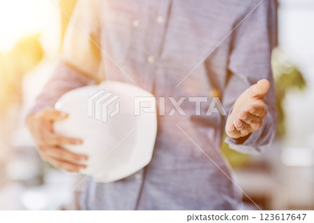 Architect and civil engineer shaking hands while holding hard hat in hand 123617647