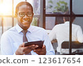 a man at a workplace at a table in front of a computer uses a tablet 123617654