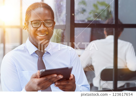a man at a workplace at a table in front of a computer uses a tablet a man at a workplace at a table in front of a computer uses a tablet 123617654