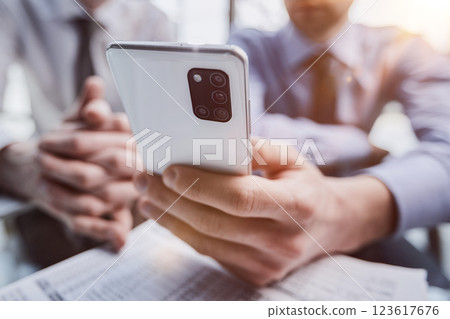 Close up of young business man using mobile smart phone 123617676