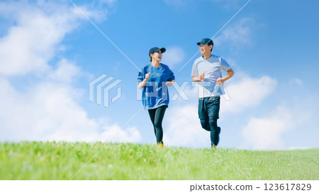 Two men and women jogging under the blue sky Two men and women jogging under the blue sky 123617829