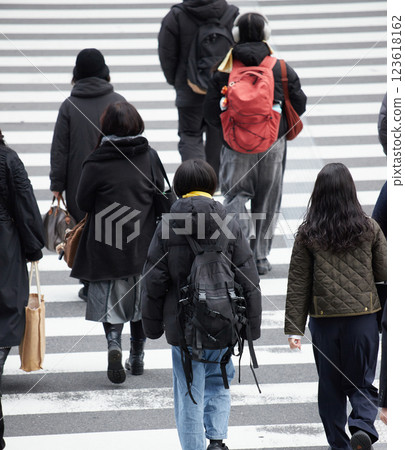 People crossing a crosswalk at an intersection in a winter city People crossing a crosswalk at an intersection in a winter city 123618162