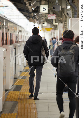 Office workers waiting for a train on a station platform in winter Office workers waiting for a train on a station platform in winter 123618300