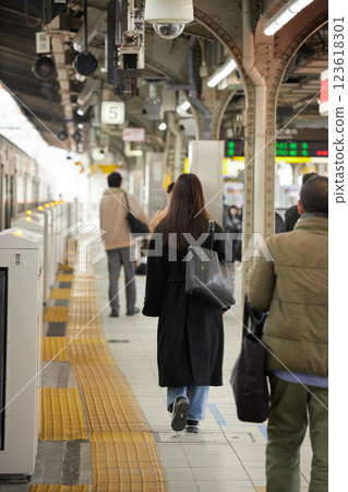 People waiting for a train on a station platform in winter People waiting for a train on a station platform in winter 123618301